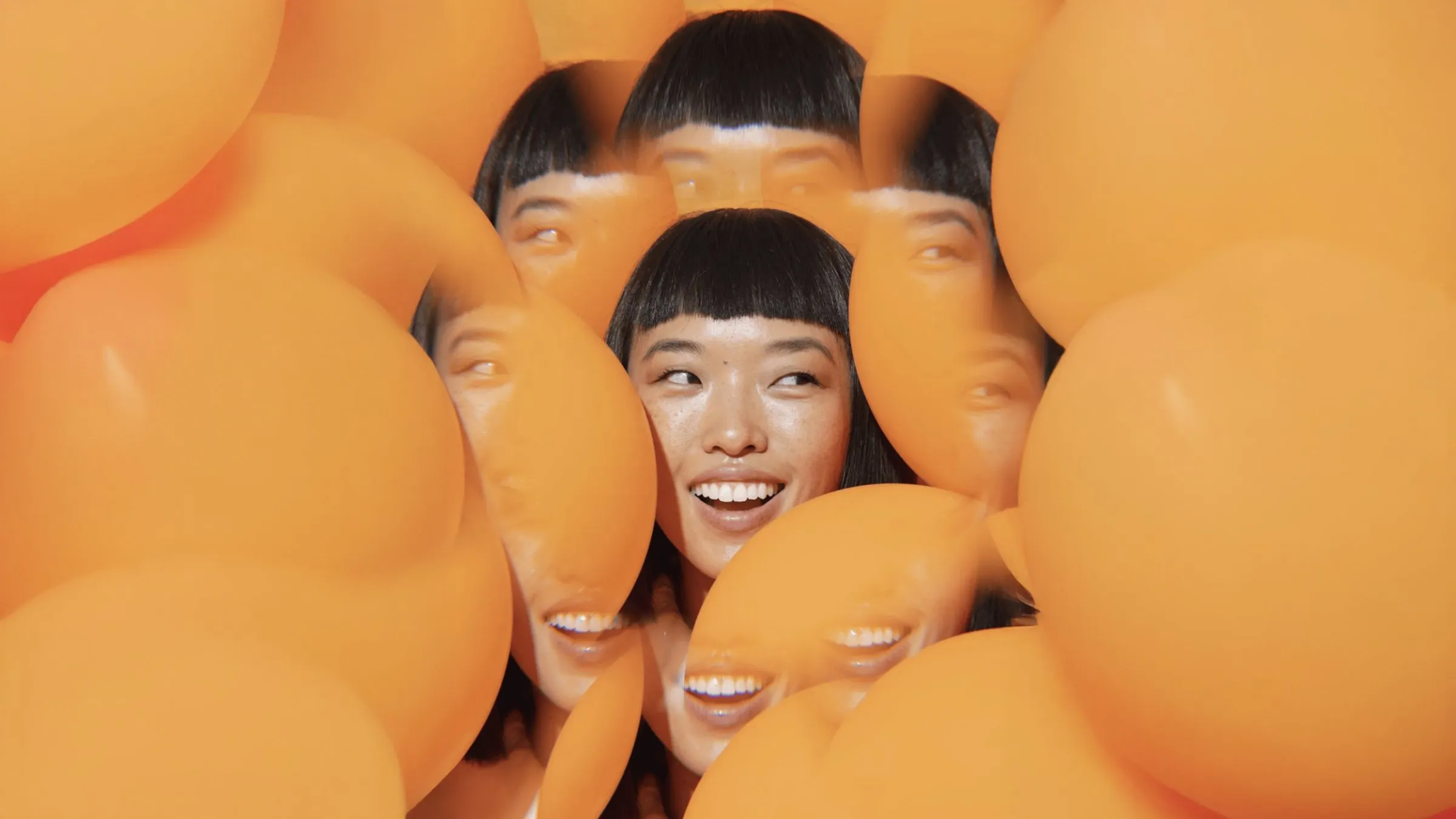 Smiling student surrounded by orange portrait cut-outs