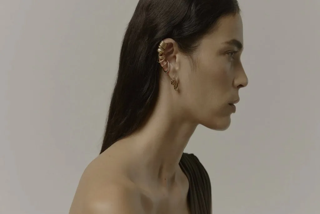 Profile of a model wearing gold ear jewellery
