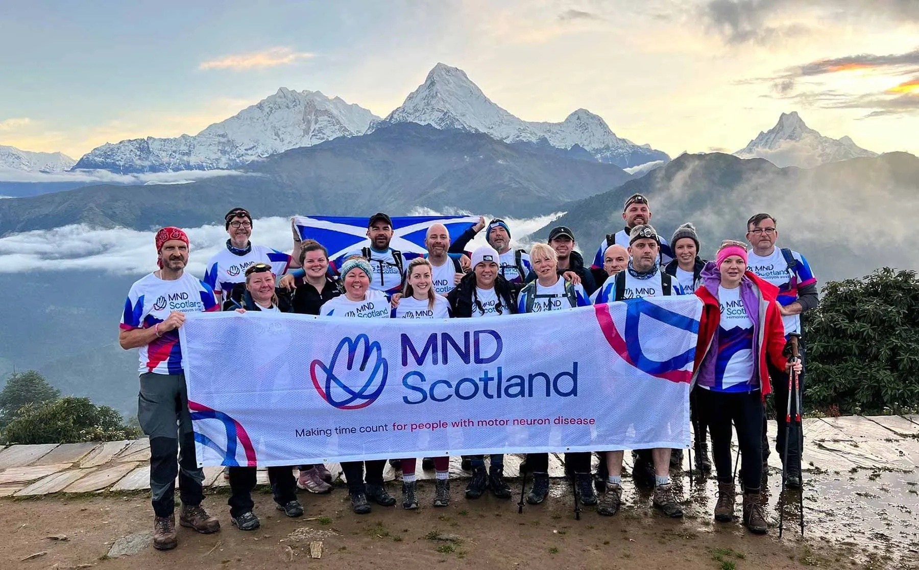 MND Scotland fundraising trekkers holding a banner in the Himalayas