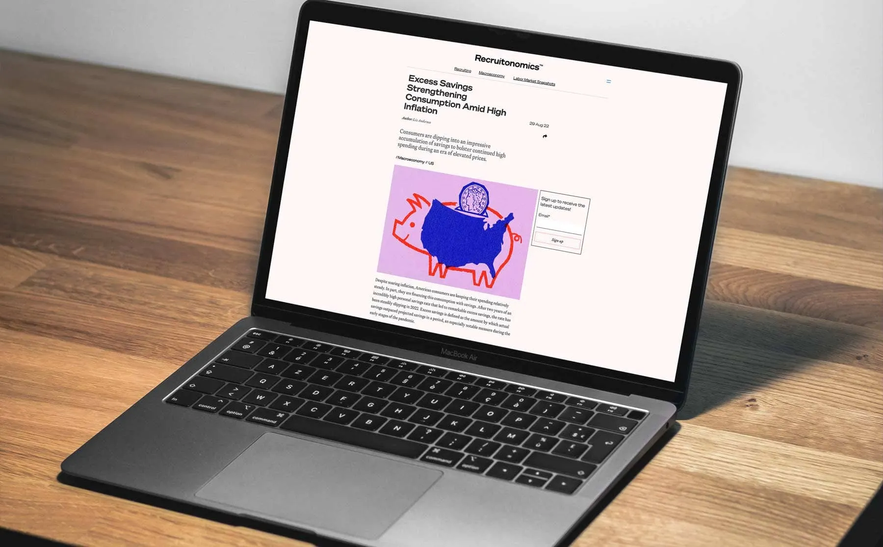A laptop showing a Recruitonomics article with a piggy bank illustration